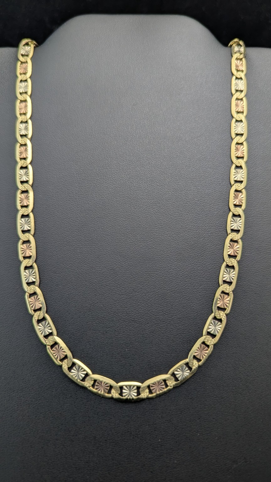 22-inch tri-color 14K gold Gucci-link chain with patterned yellow, white and rose tones on a dark jewelry display